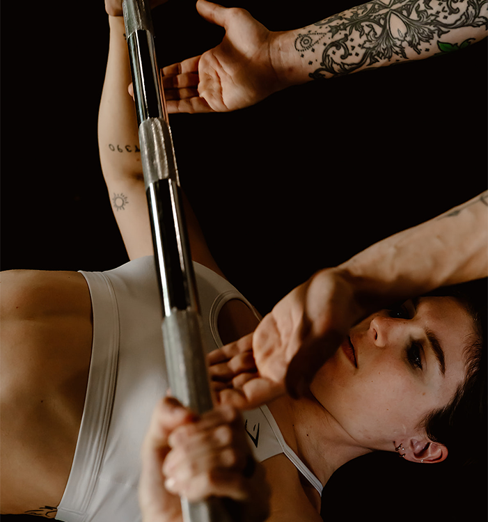 fitness coach spotting a woman bench pressing