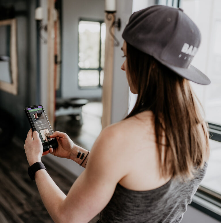 online personal trainer checking on clients on her phone